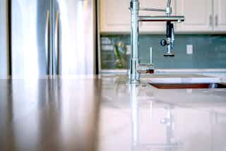 A remodeled kitchen with a hammered copper sink and a spray faucet