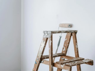 A photograph of a newly drywalled room that is being painted