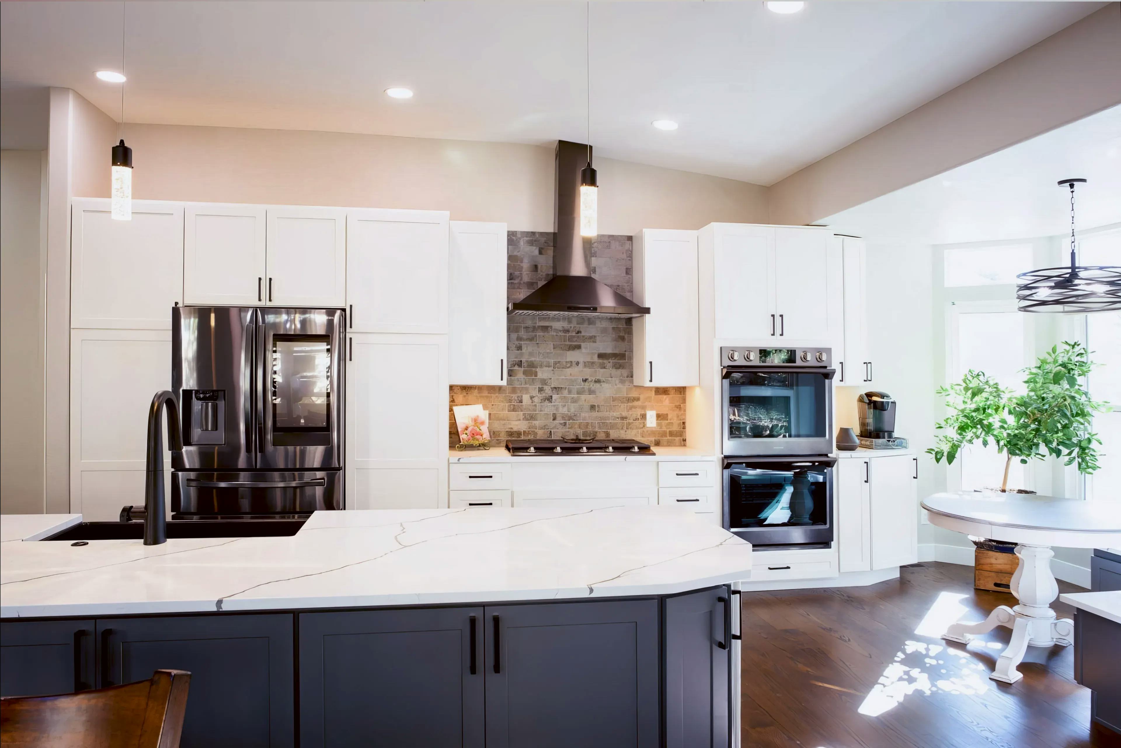 A photo that is straight on to Trayce's kitchen remodel in Colorado Springs with white counter tops, a stainless  steel oven hood and white cabinets 