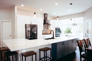 Trayce's kitchen remodel in Colorado Springs with white counter tops, a stainless  steel oven hood and white cabinets