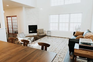 A photograph of a newly remodeled great room with wooden flooring and a minimal design with white walls